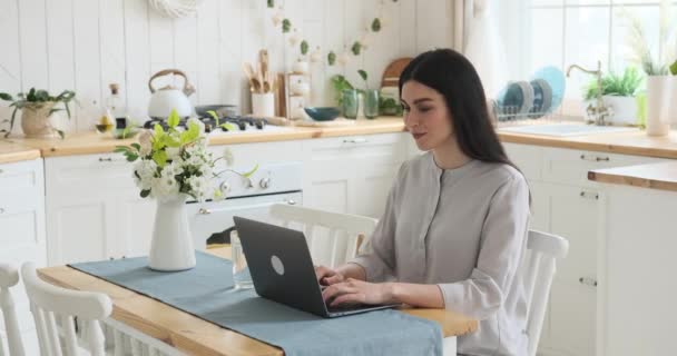 Odaklanmış Beyaz Bir Kadın Mutfak Masasında Oturuyor Dizüstü Bilgisayarda Yazıyor — Stok video