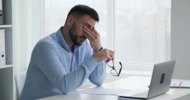 İş kıyafetleri ve gözlükleri içinde yorgun beyaz bir işadamının masasında dinlenmesi, gözlerini ovması ve uzun iş günlerinin yorgunluğundan boynuna masaj yapması biraz zaman alır..