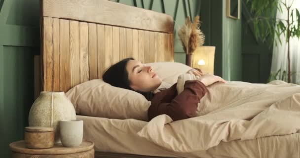잠옷을 여성의 잠에서 깨어남에 얼굴은 만족을 발산한다 침대의 만끽하면서 만족스럽게 — 비디오