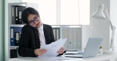 Kararlı bir Hintli işkadını ofisinde masasında oturmuş, bir telefon görüşmesine dalmış. İşle ilgili işleri ustalıkla hallederken aynı zamanda masa başındaki evrak işleriyle de ilgileniyor..