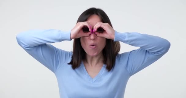 행복하고 여자가 배경에 무엇인가를찾고 가까이에 쌍안경으로 몸짓을 흥분해서 — 비디오