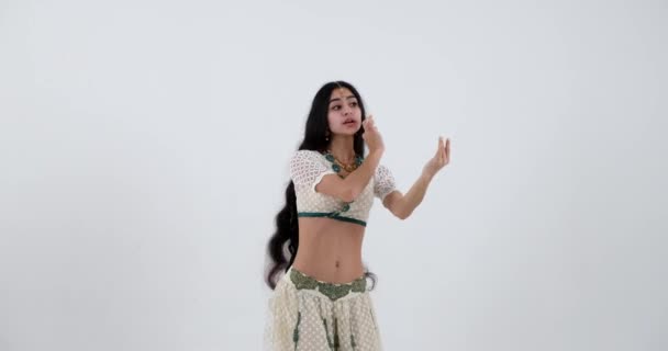インドの伝統舞踊の若い女性のパフォーマンス 彼女の白いサリーは 彼女の活気のある動きと表現のジェスチャーのための完璧な背景を提供します — ストック動画