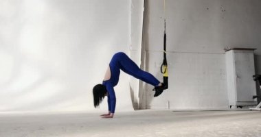 Spor giyimli formalı bir kadın vücut kaslarını güçlendirmek için tahta egzersizleri yapar. Dizlerini kıstırmak da dahil olmak üzere çeşitli tahta egzersizleri yaparken formda kalıyor.