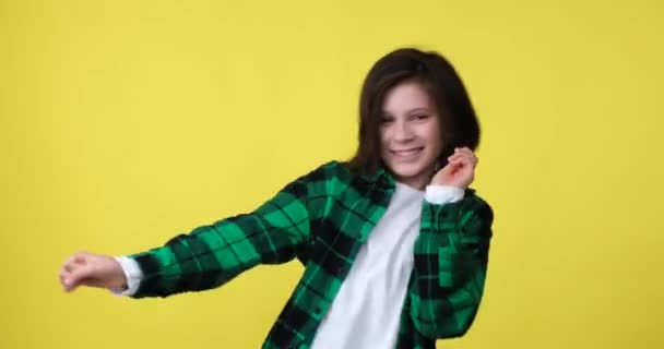 Счастливый Школьник Клетчатой Рубашке Стоит Жёлтом Фоне Танцуя Беззаботными Легкими — стоковое видео
