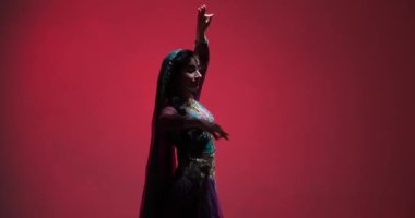 Genç bir Hintli kadının geleneksel Bharatanatyam dansının güzel performansı. Özgün kostüm ve mücevherleri, yetenekli koreografisi ile birleşti..