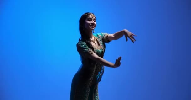 インド舞踊の表現と動きを示すインドの女性は 生き生きとした風景と伝統的なジュエリーで魅惑的なバラタナティームのルーチンを専門的に実行します — ストック動画