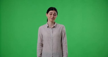 Kafkas bir kadının yavaş çekimde portresi yeşil perde arkasında duruyor, omuzlarını kaldırıyor ve kollarını karmaşa ve belirsizlik içinde açıyor, sanki ne söyleyeceğini ya da yapacağını bilmiyormuş gibi..