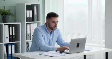 İşletme yöneticisi masasında oturmuş önündeki kağıtlara ve grafiklere bakıyor. Verileri karşılaştırmak için laptopunu kullanıyor ve rekabetin önünde kalmaya çalışıyor..