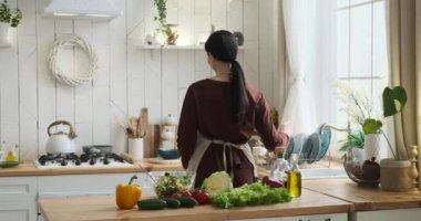 Yetenekli beyaz kadın mutfakta, salata hazırlıyor. Taze malzemeleri karıştırarak, onları bir kasede tahta bir kaşıkla karıştırıyor. Salatayı zarifçe tabağa aktarıyorum..