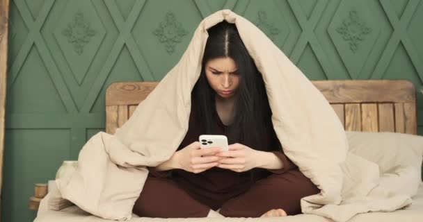 Λευκή Γυναίκα Κάθεται Στο Κρεβάτι Ντυμένη Άνετες Πιτζάμες Είναι Απορροφημένη — Αρχείο Βίντεο
