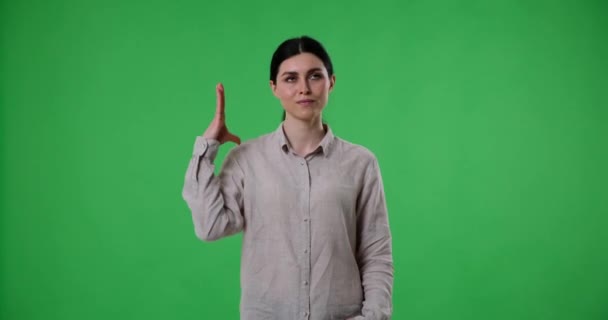 Blanke Vrouw Staat Tegen Een Groene Achtergrond Het Scherm Kijkt — Stockvideo