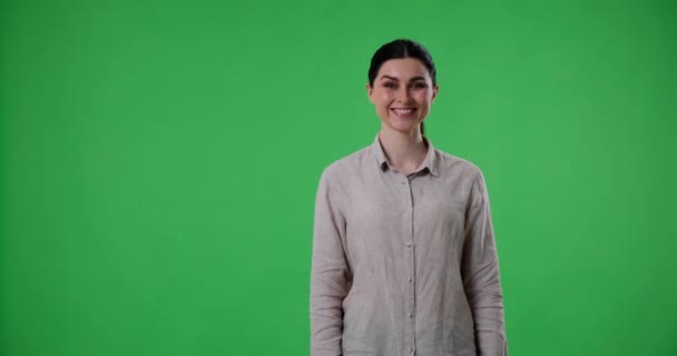 Yeşil Perde Arkasında Duran Neşeli Beyaz Bir Kadın Gülümsüyor Işaret — Stok video