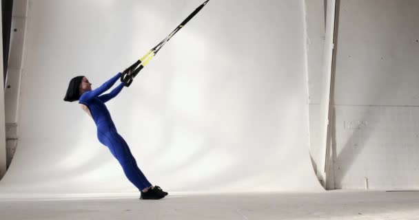 Kobieta Niebieskim Stroju Sportowym Podciąga Się Pomocą Opasek Fitness Ćwiczenie — Wideo stockowe
