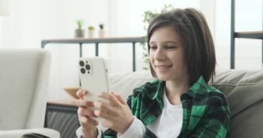 Kanepede oturan genç bir çocuk, cep telefonuna dalmış. Kendini sanal aleme daldırırken, gözler ekranda sabit kalıyor, ya ilgi çekici videolar izliyor ya da en sevdiği melodilerin tadını çıkarıyor..