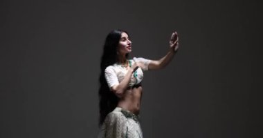 Bu yetenekli Hintli dansçıyı beyaz bir sari içinde karmaşık detaylar ve parlak mücevherlerle klasik dans ederken izleyin. Zarif hareketleri ve baştan çıkarıcı ifadeleri seni büyüleyecek..