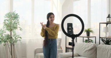 Hintli içerik yaratıcısı cep telefonuyla video blogunu yakalıyor. Sınırsız enerjisiyle, düşüncelerini paylaşıyor, dinleyicileriyle bağlantı kuruyor ve hareketli bir şekilde hareket ediyor..