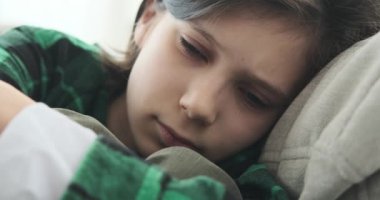 Oturma odasındaki kanepede oturan genç bir çocuk hüzün dolu bir ana dalmıştı. Onun aşağılayıcı bakışları ve ince hareketleri derin bir melankoli hissi taşıyor..