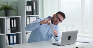 Gözlüklü beyaz iş adamı, işini konuşmak için bilgisayarından bir video görüşmesi yapıyor. Şirketinin başarısını aktarmak için grafik ve büyüme göstergelerine sahip belgeler sergiliyor..