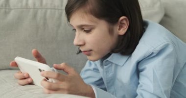 Kanepede yatan okul çağındaki bir çocuk. Yüzünü aydınlatan bulaşıcı bir gülümseme ile, kendini sanal dünyaya daldırıyor, heyecan verici zorluklar ve zaferler arasında yol alıyor..