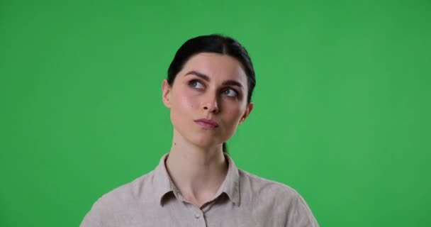 Mujer Está Pie Contra Una Pantalla Verde Contemplando Mirando Alrededor — Vídeos de Stock