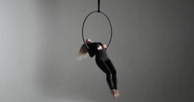 Hava çemberindeki beyaz kadın dans için yeteneğini ve tutkusunu sergiliyor. Karanlık bir arkaplanda, ışığın kontrastı her dönüşünde onu aydınlatır..