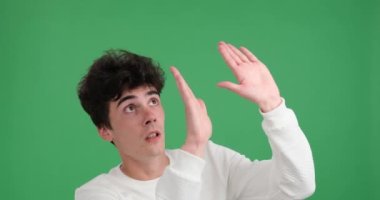 Kafkasyalı bir adam yakınına düşen bir şeye tepki veriyor. Canlı yeşil bir arkaplan karşısında, onun geniş gözlü yüz ifadesi ve eller bir alarm ve şaşkınlık duygusu iletir.