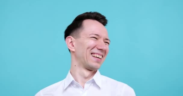 Mavi Arka Planda Dikilip Doğrudan Kameraya Bakan Mutlu Beyaz Adam — Stok video