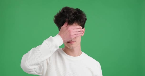 Caucasian Man Covers His Eyes His Hand Captivating Green Background — Stock Video