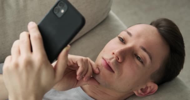 Hombre Caucásico Reflexivo Reclinado Sofá Profundamente Inmerso Teléfono Con Una — Vídeos de Stock