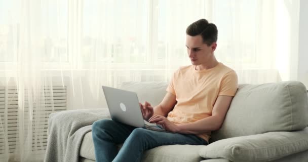 Soustředěný Muž Sedí Doma Pohodlném Gauči Píše Svém Notebooku Odhodlaným — Stock video