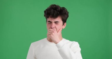 Beyaz adam ferahlatıcı yeşil arka plana karşı ezici bir yorgunluğa yenik düşer. Gözleri sarkmış ve ağzı sonuna kadar açık derin bir esnemede yorgunluğun evrensel sembolünü çiziyor..