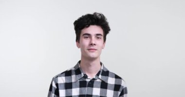 Temiz beyaz arka planda karizmatik kıvırcık saçlı beyaz bir adam. Gözleri ışıldıyor ve kahkahaya boğulurken yüzünde geniş bir gülümseme yayılıyor..