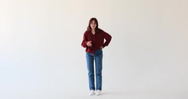 Neşeli beyaz bir genç kız, beyaz perdenin arka planına karşı, spot ışıklarını alır ve canlı konuşma becerisiyle izleyicileri cezbeder..