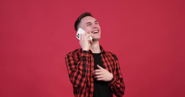 Pulzujícím Červeném Pozadí Šťastný Běloch Zapojí Přátelského Telefonického Rozhovoru Rozzářeným — Stock video