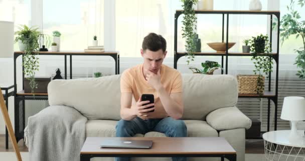 Hombre Sentado Sofá Casa Cara Llena Dolor Decepción Con Teléfono — Vídeos de Stock