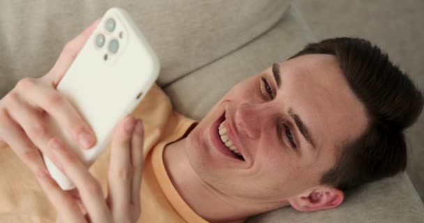 Žoviální Muž Ležel Pohovce Jeho Nakažlivý Smích Naplňoval Místnost Telefonem — Stock video