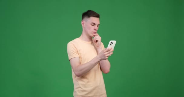 Serious Caucasian Man Green Background Uses His Phone Vibrant Green — Stock Video