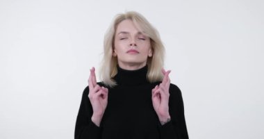 Umut dolu beyaz arka planda duran beyaz tenli kadın, şans diliyor. İçten bir gülümseme ve beklenti duygusuyla bir şeyi dileme ya da umut etme eylemini sembolize ediyor..