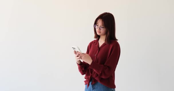 Una Alegre Adolescente Caucásica Involucra Con Teléfono Telón Fondo Blanco — Vídeo de stock