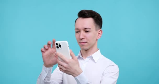 Büyüleyici Bir Mavi Arkaplan Karşısında Duran Beyaz Bir Adam Telefonuyla — Stok video
