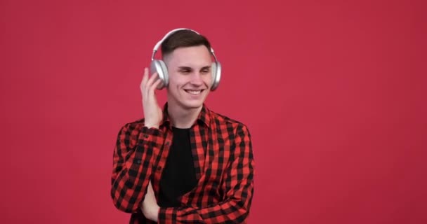 Punaisella Taustalla Iloinen Valkoihoinen Mies Joka Nauttii Musiikistaan Hänellä Rento — kuvapankkivideo