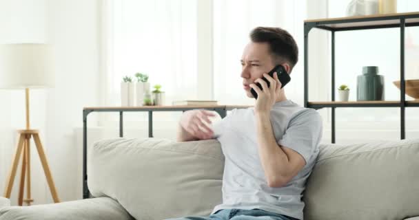 Uomo Caucasico Concentrato Seduto Divano Assorto Una Conversazione Telefonica Importante — Video Stock