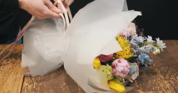 Mężczyzna Kwiaciarnia Skrupulatnie Wiąże Bukiet Pięknych Kwiatów Wstążką Niezachwianą Precyzją — Wideo stockowe