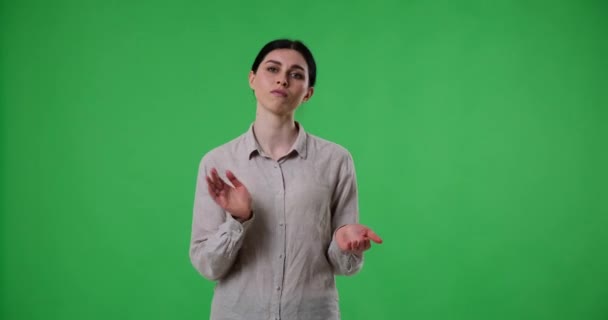Ongeïnteresseerde Blanke Vrouw Staat Tegen Een Groene Achtergrond Het Scherm — Stockvideo