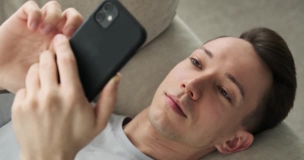 Hombre Caucásico Descansando Sofá Completamente Absorto Teléfono Con Una Sonrisa — Vídeo de stock