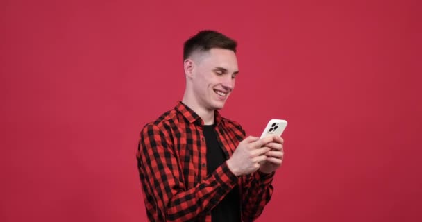 Canlı Kırmızı Arka Planda Neşeli Beyaz Bir Adam Telefonunda Neşeli — Stok video