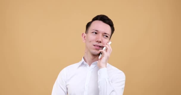Biały Mężczyzna Stojący Spokojnym Beżowym Tle Używa Telefonu Rozmawia Radosnym — Wideo stockowe