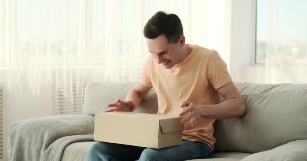 Běloch Sedící Pohovce Reaguje Pocitem Zděšení Když Obdrží Balíček Jeho — Stock video