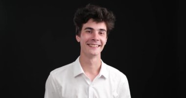 Siyah bir arka planda, beyaz bir adam elini uzatıyor, baş parmak işareti yapıyor. Baş parmağı yukarı ve parmaklarının geri kalanı kıvrılmış bir şekilde, bir pozitiflik mesajı iletir..