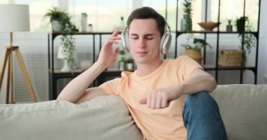 Huzurlu bir ortamda rahat rahat rahat koltukta oturan bir adam. Bir çift şık kulaklık takıyor, kendini müzik dünyasına kaptırma niyetini gösteriyor..